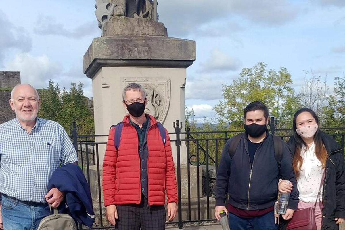 a group of people wearing masks standing in front of a gate