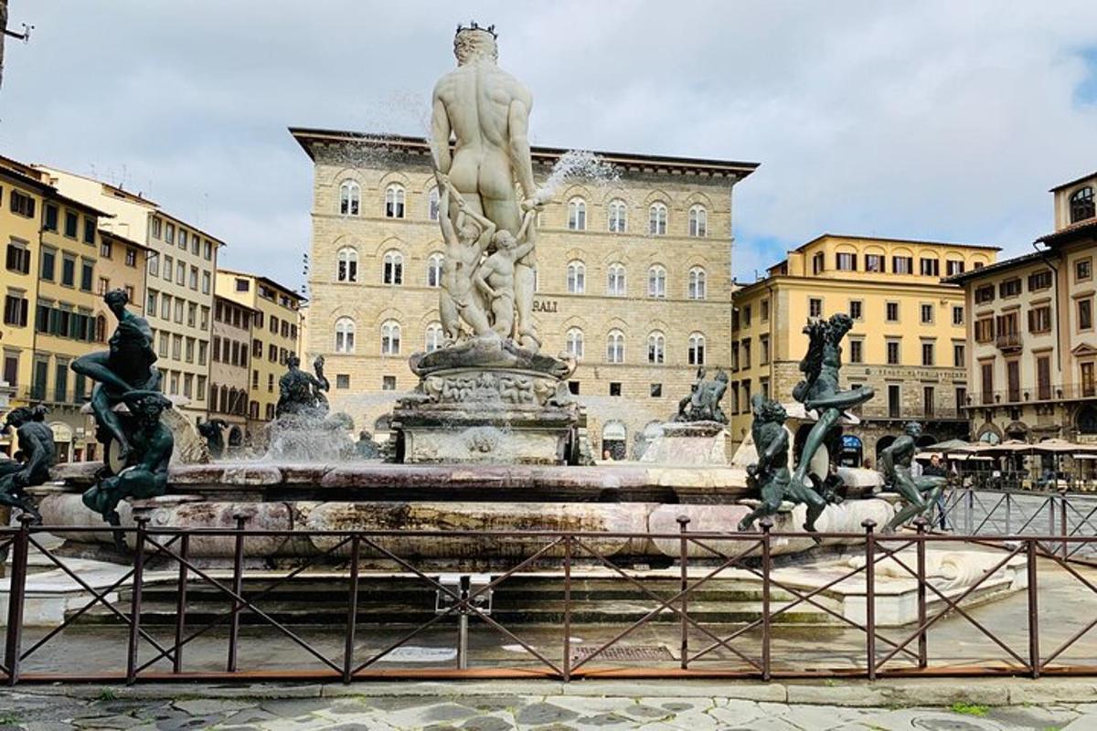 una estàtua d'un home assegut a sobre d'una font