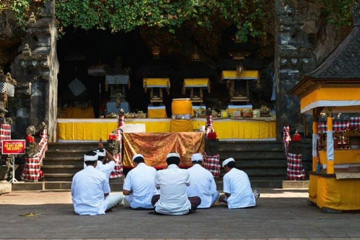 un grup de bărbați așezați în fața unui templu