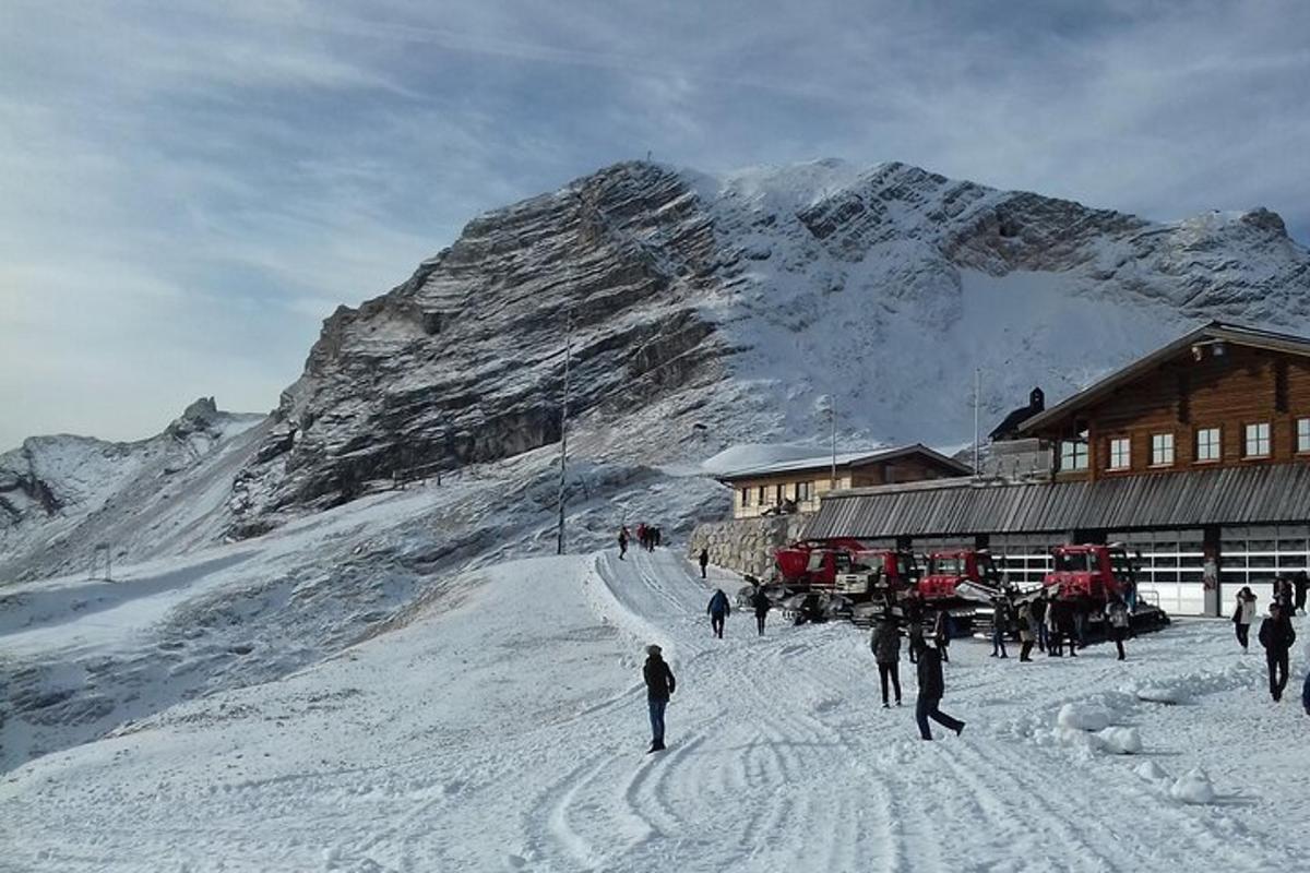un gruppo di persone sulla neve vicino a un rifugio sciistico