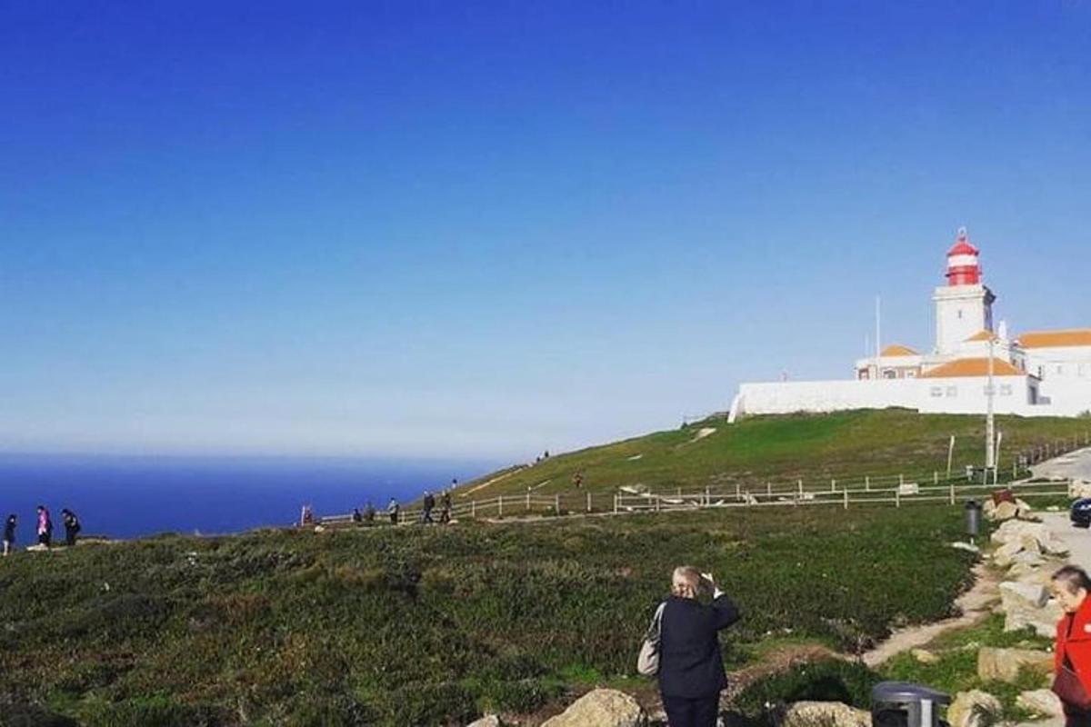 Una mujer parada en una colina con un faro