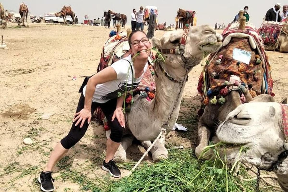 a woman sitting on a camel in a field