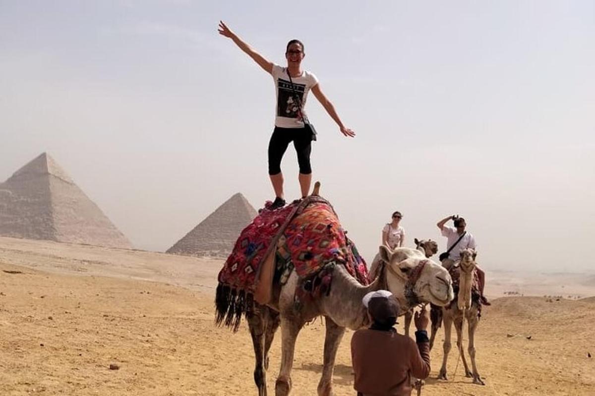 a woman riding on the back of a camel in the pyramids
