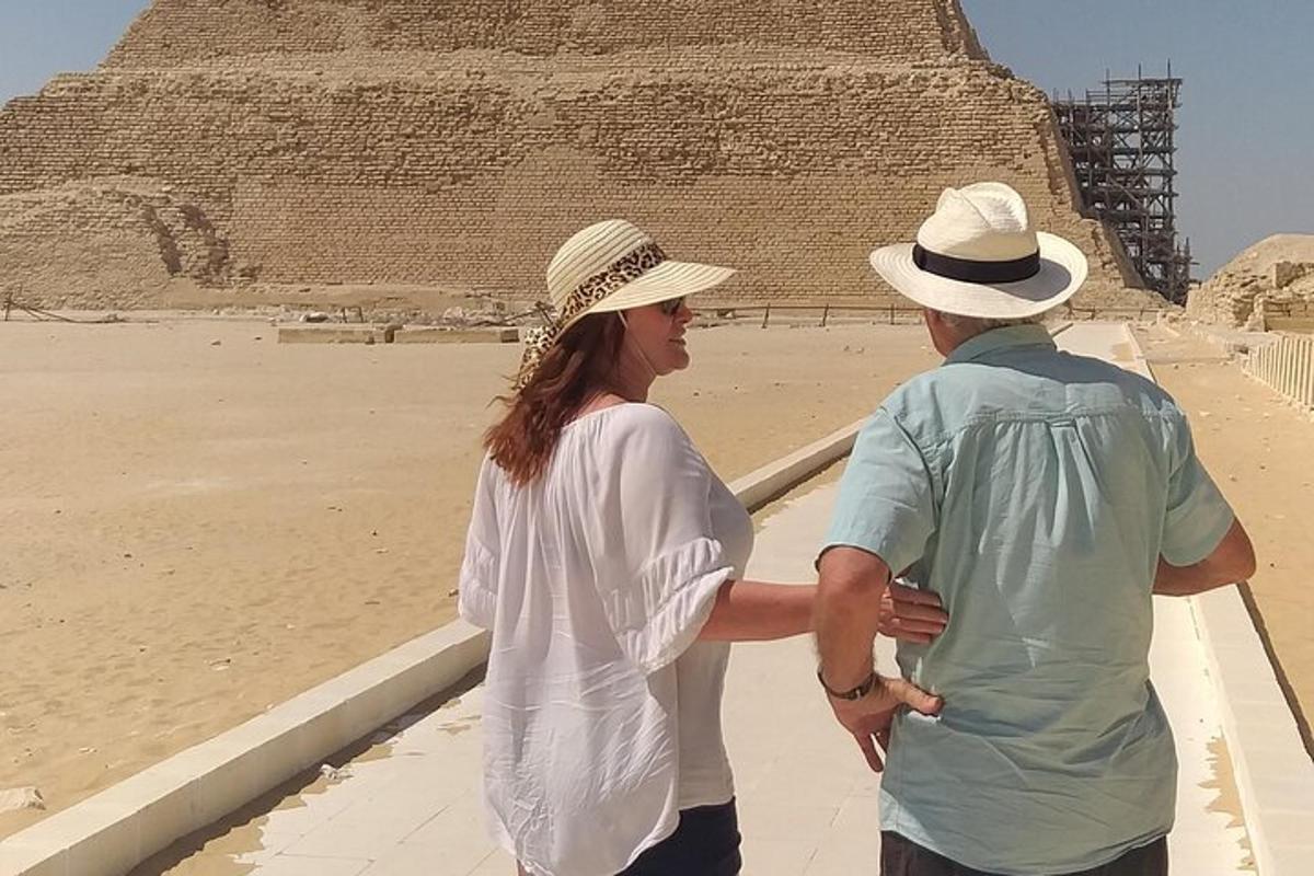 a man and a woman standing in front of the pyramid