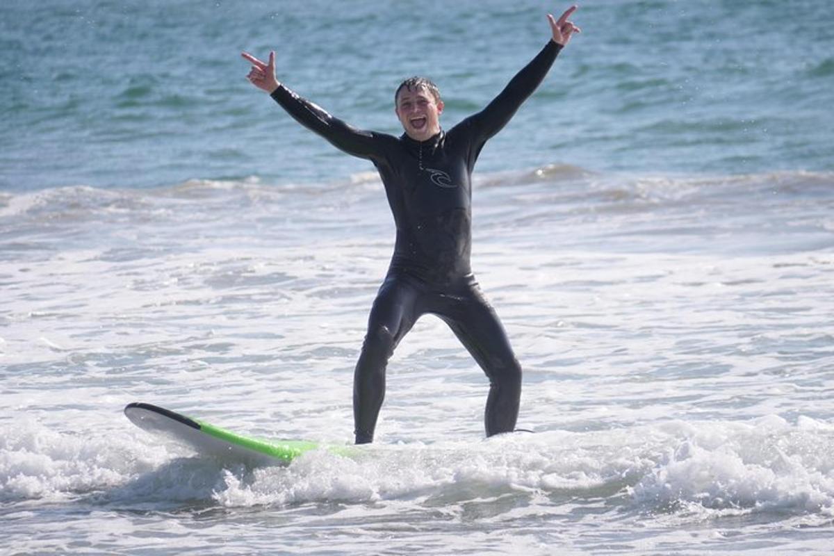 una dona dempeus sobre una taula de surf a l'oceà
