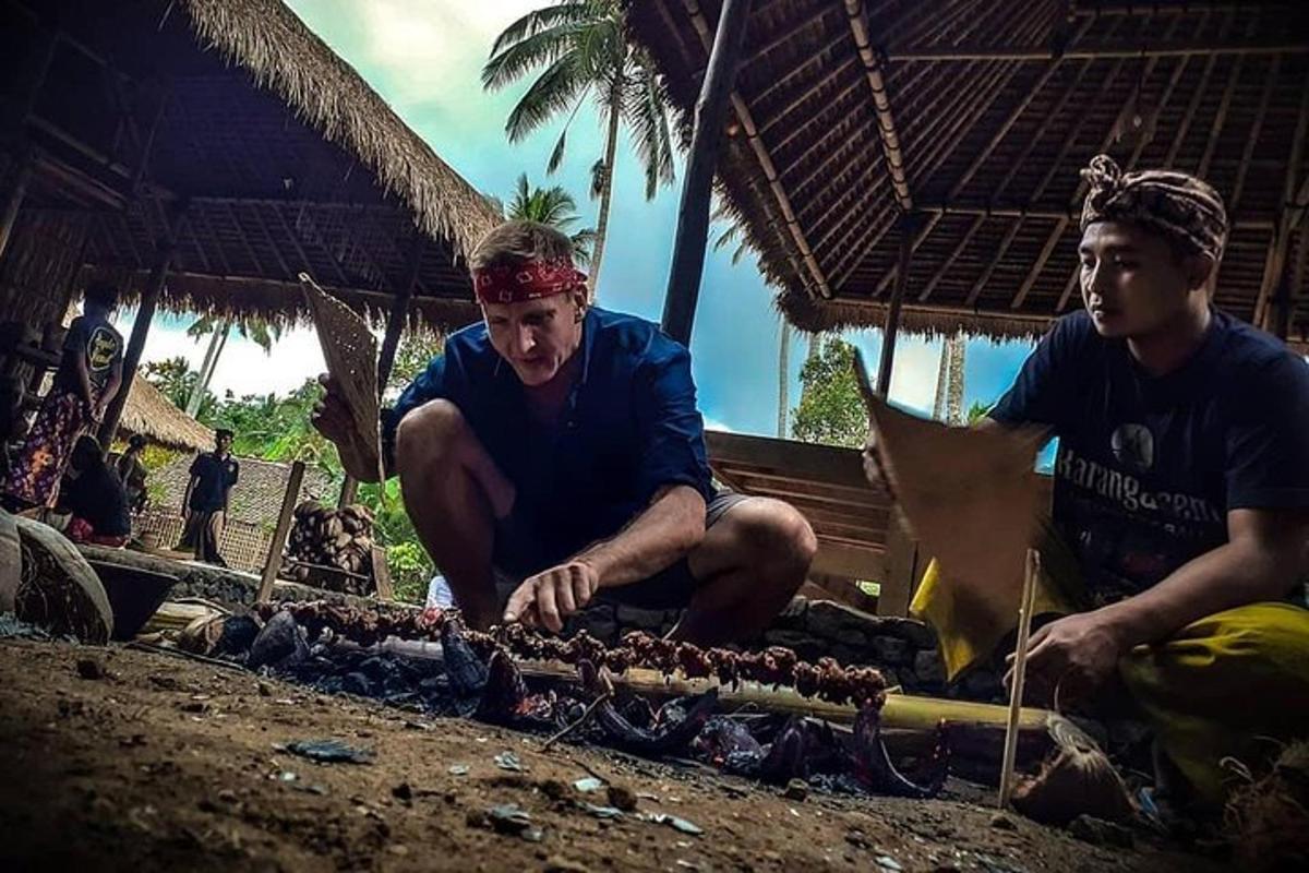 two men are preparing food on a beach