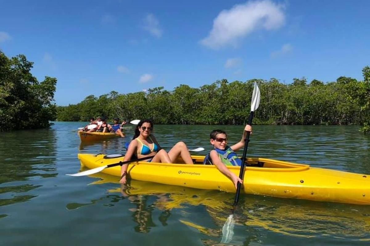 a man and woman in a yellow kayak on the water
