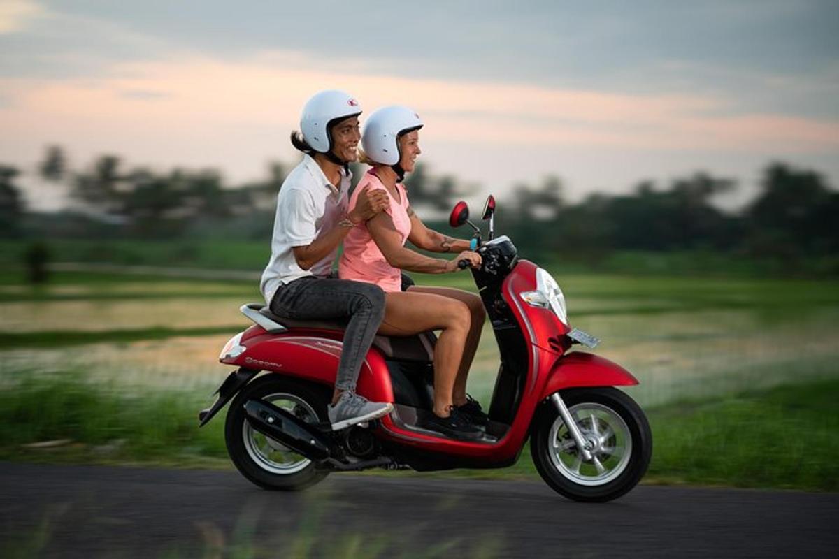 due persone che guidano uno scooter rosso su una strada