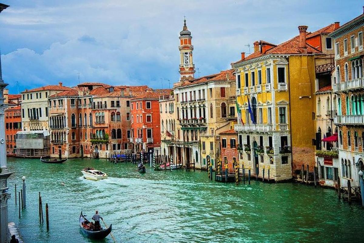 una gondola in un canale con edifici e una torre dell'orologio