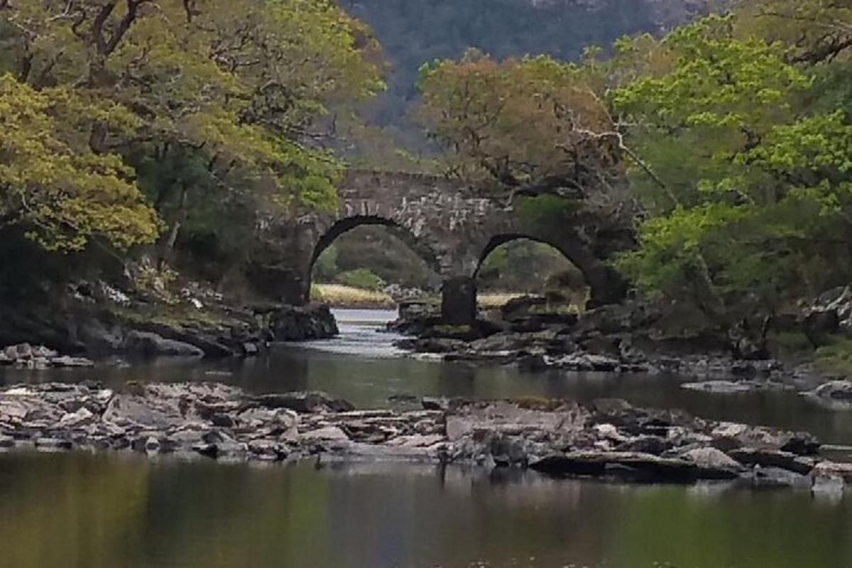 uma velha ponte de pedra sobre um rio com pedras