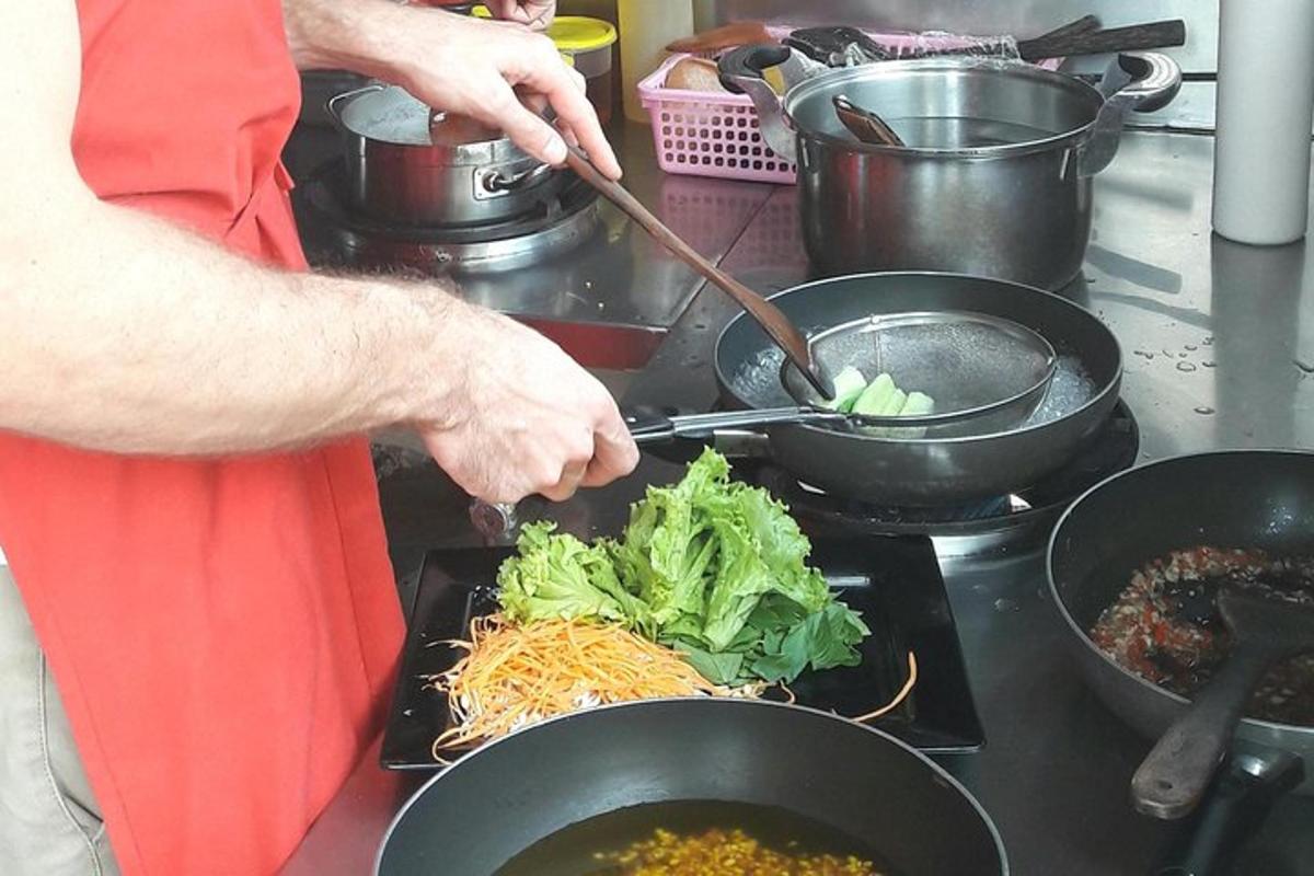 một người đang nấu thức ăn trong chảo trên bếp