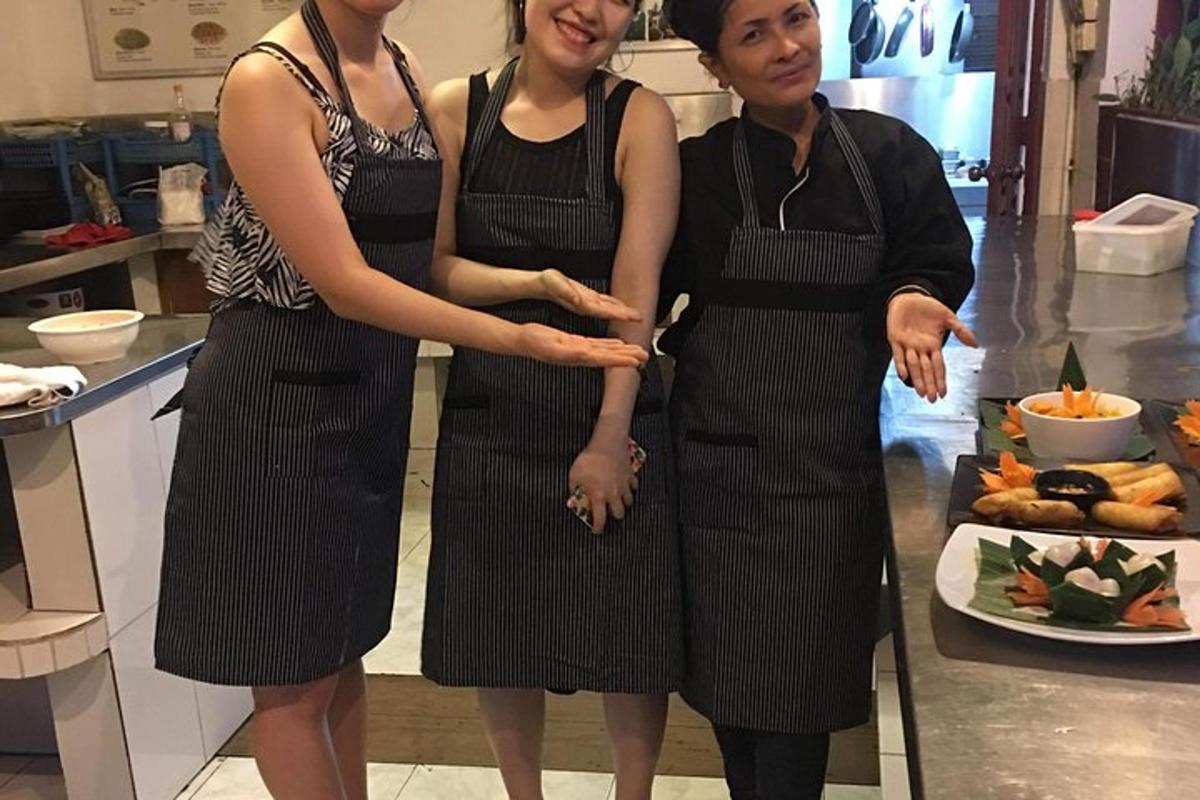ba người phụ nữ đứng trong bếp trước một chiếc bánh