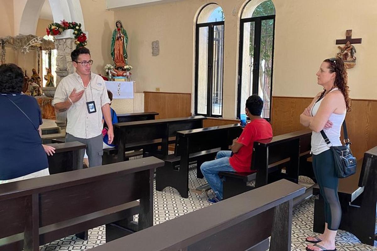 Egy nő áll egy templomban, miközben az emberek padokon ülnek