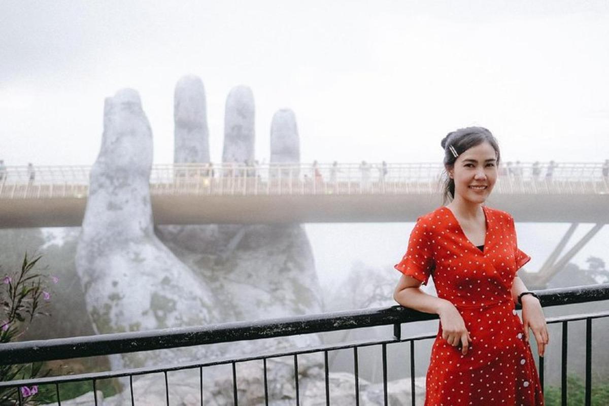 una dona amb un vestit vermell dempeus davant d'un pont