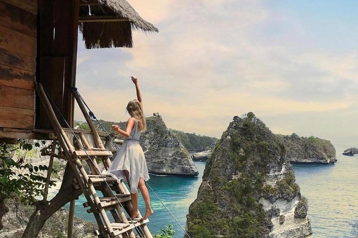 ženska, ki stoji na lestvi in gleda na ocean