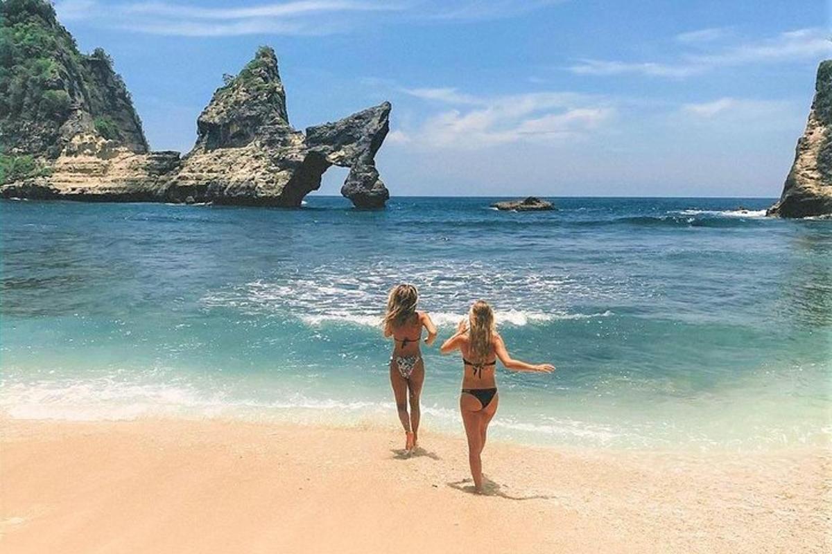 dve dekleti v kopalkah se sprehajata po plaži