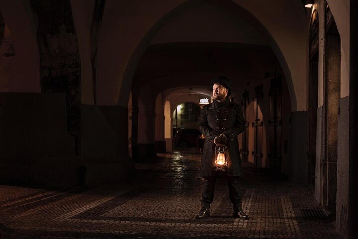 a man standing in a dark hallway with a light