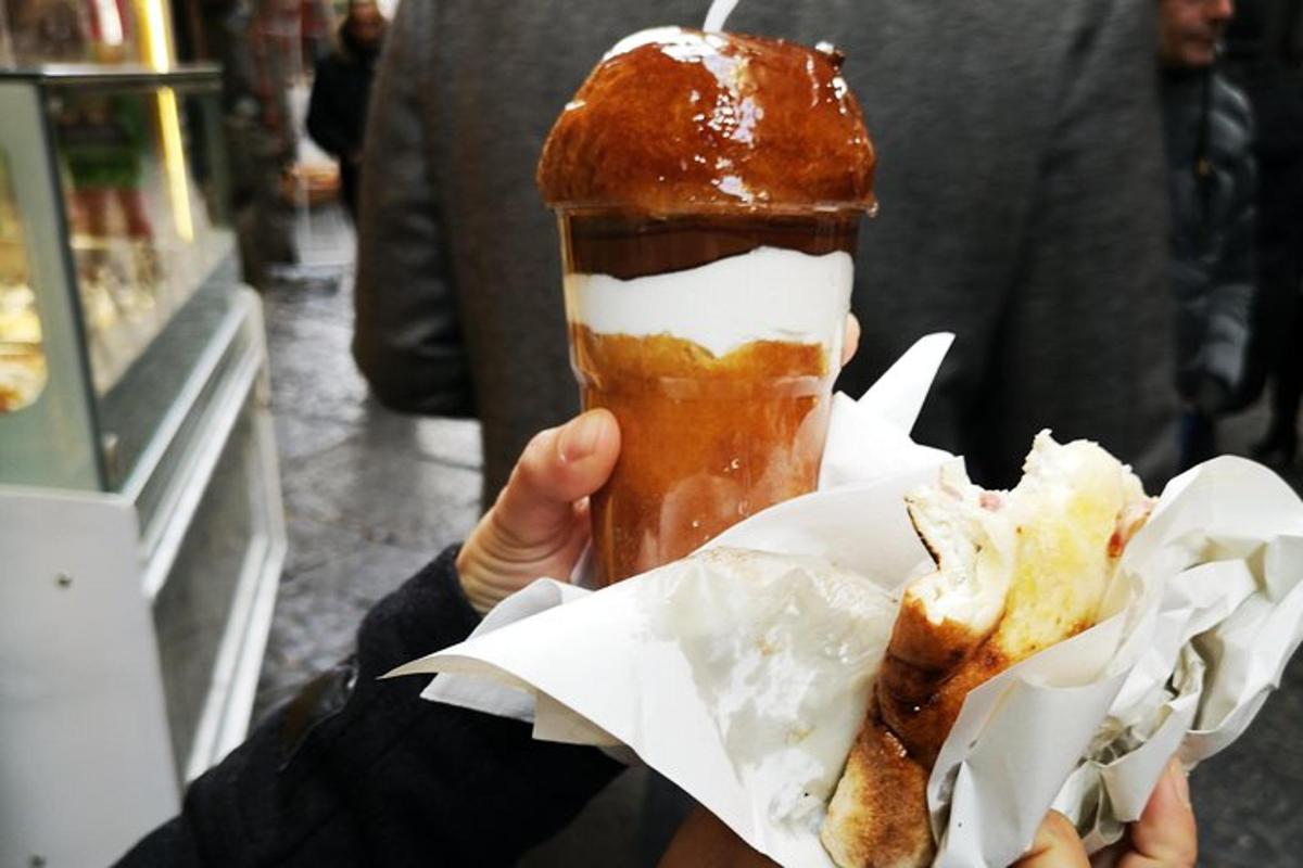 una persona tiene in mano una ciambella con una bevanda
