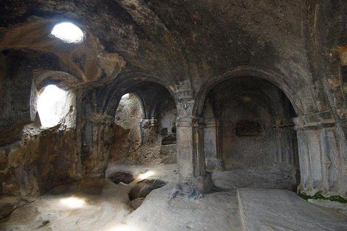 un vecchio edificio in pietra con una stanza con archi