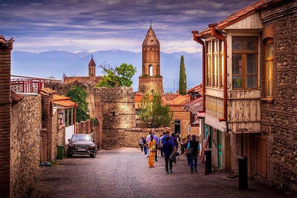 a group of people walking down a street with a clock tower