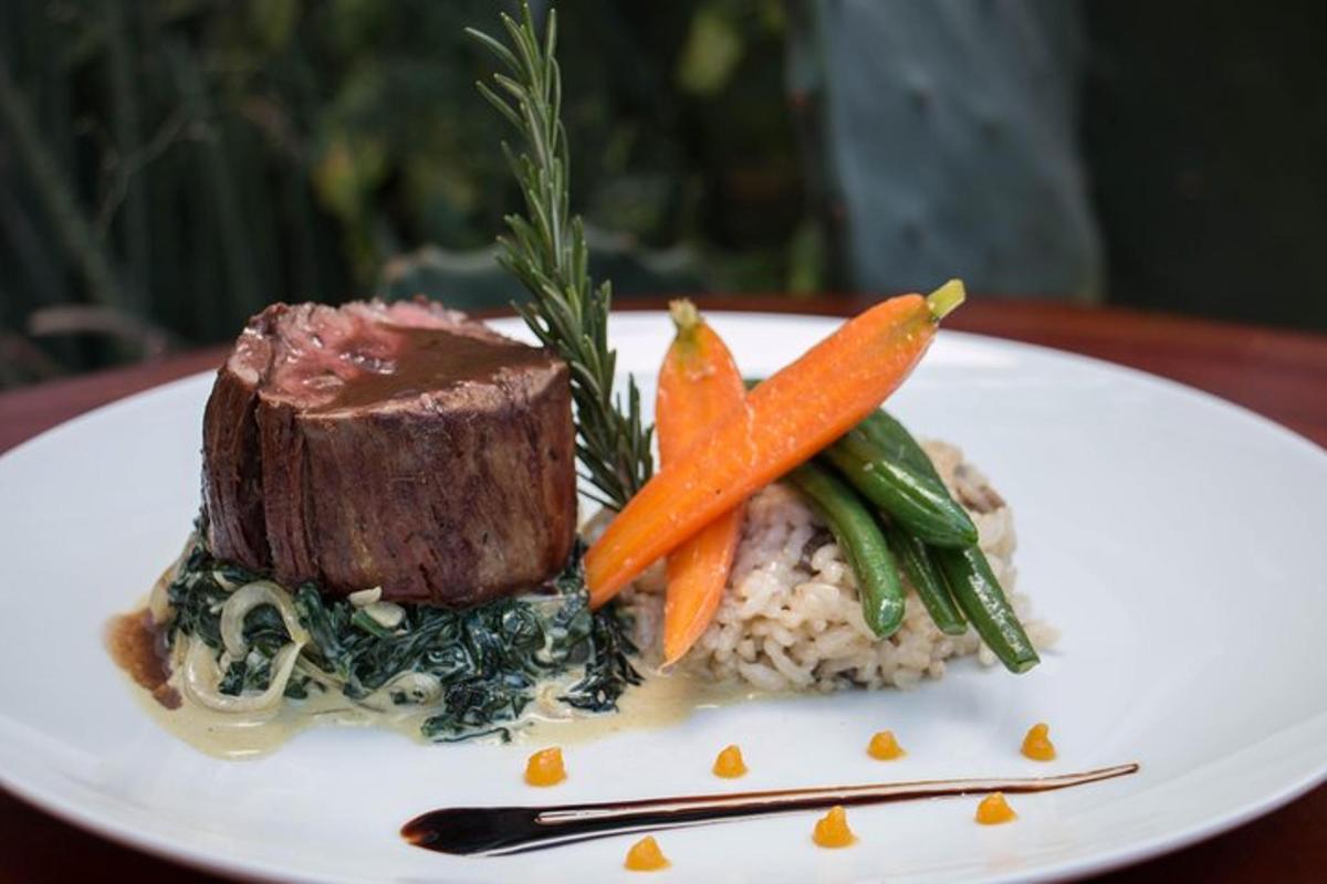 a plate of food with meat and carrots on rice