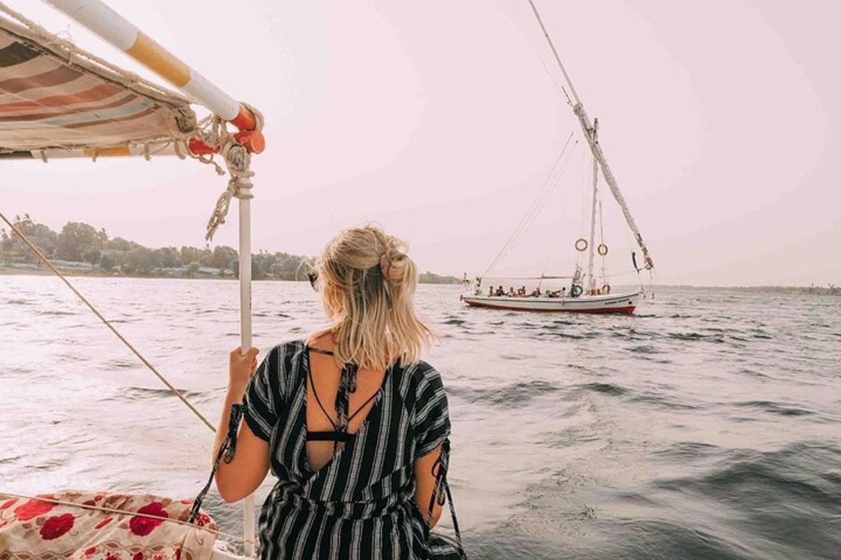 uma mulher em um barco na água com um veleiro