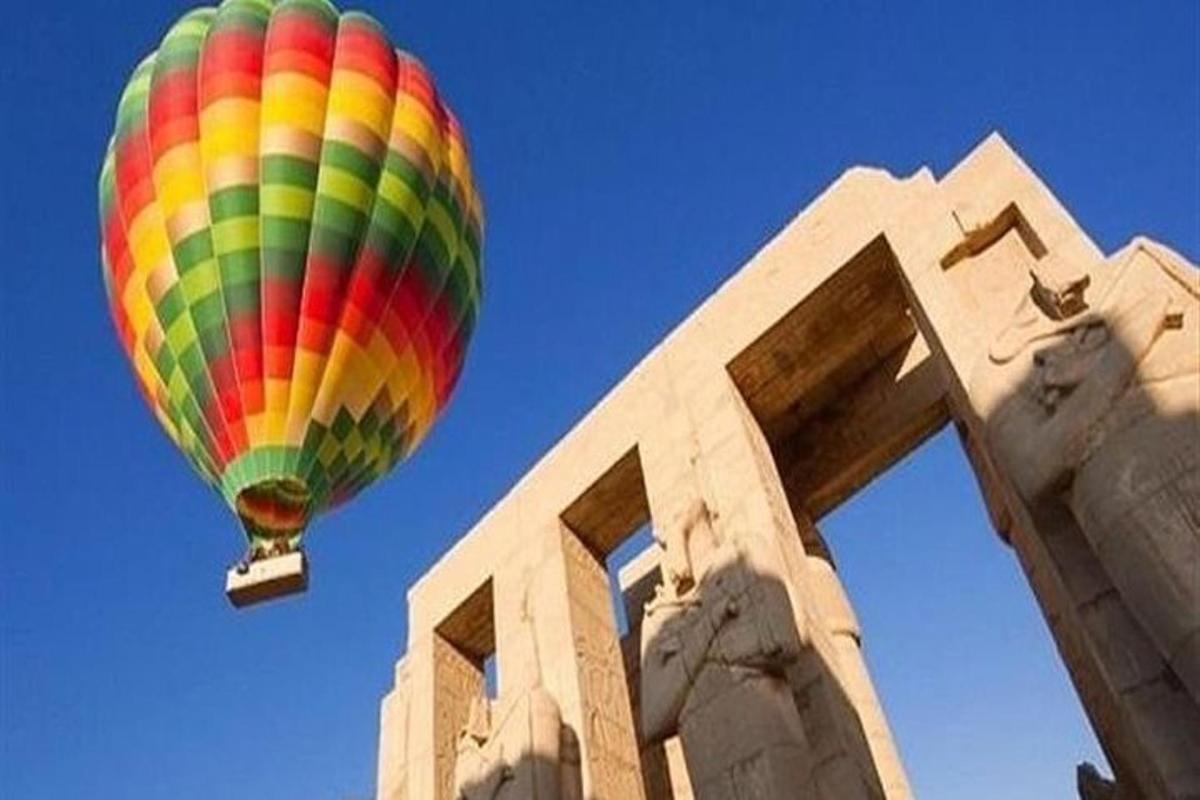 um balão de ar quente colorido voando sobre um prédio