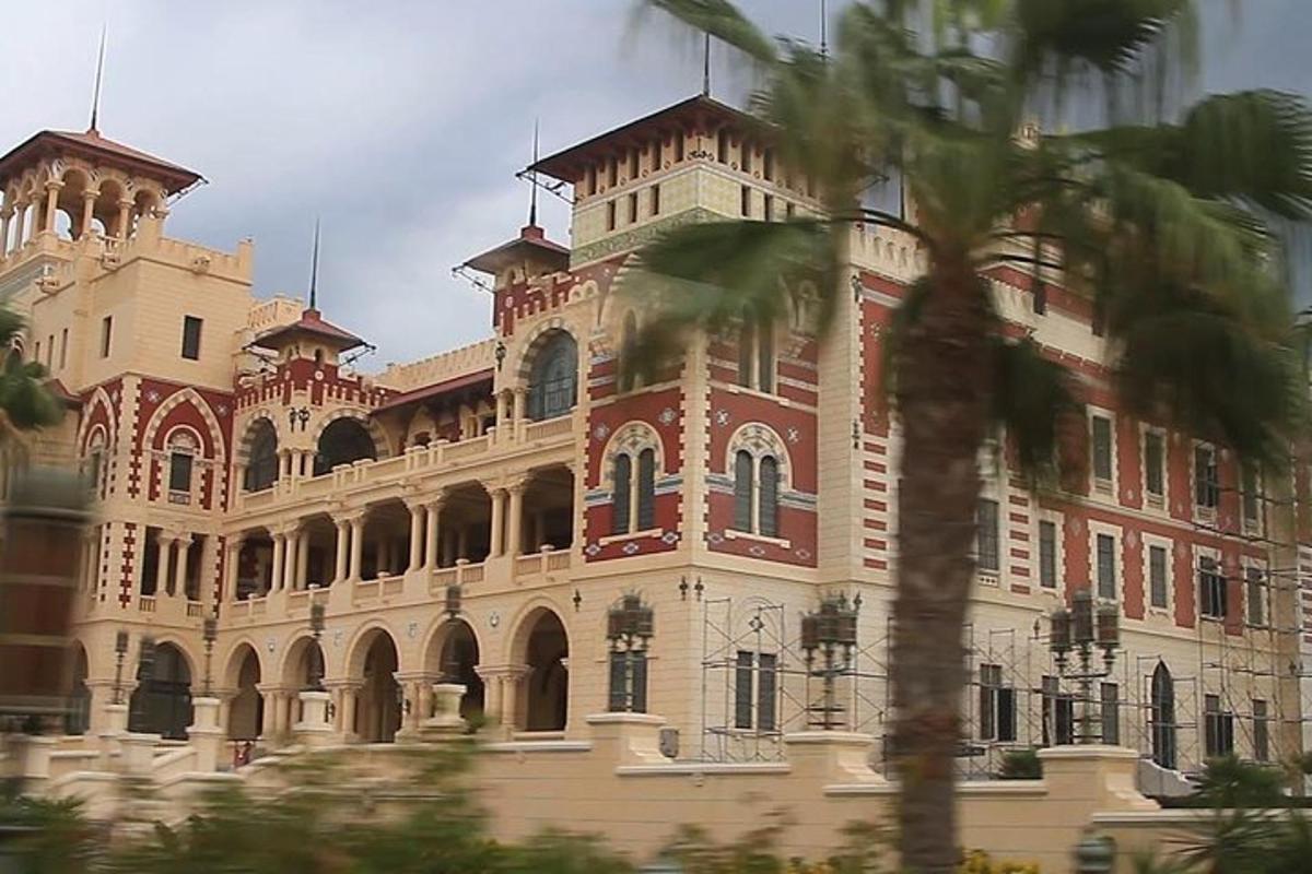 un grande edificio in mattoni con una palma di fronte