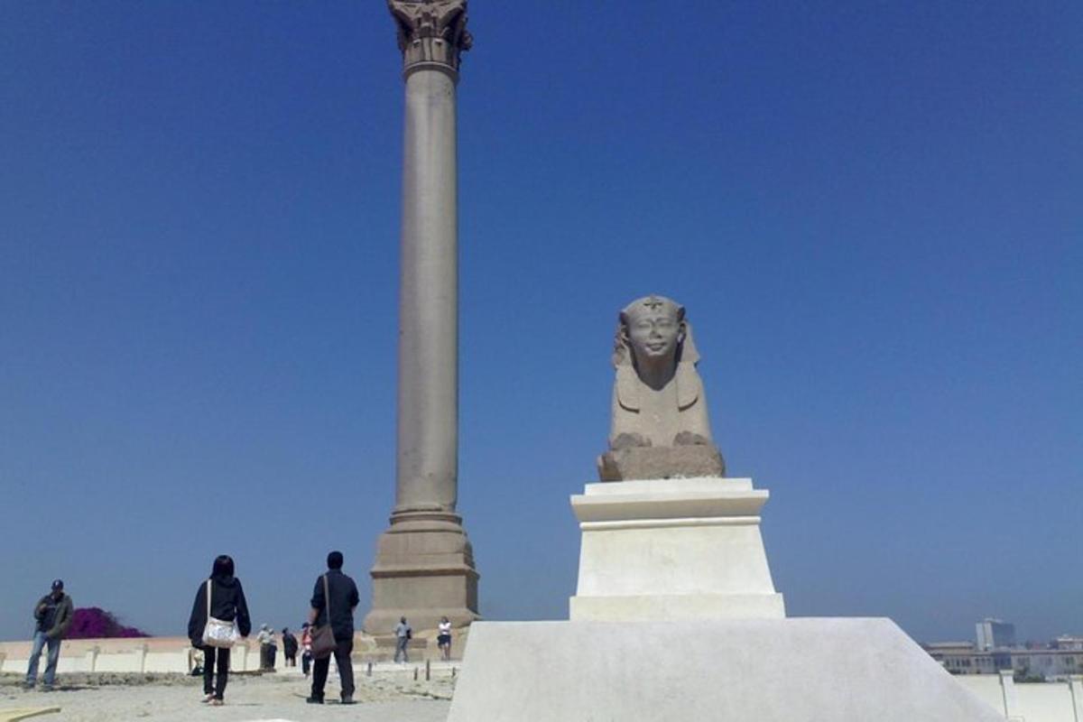 una statua davanti a una colonna e un palo