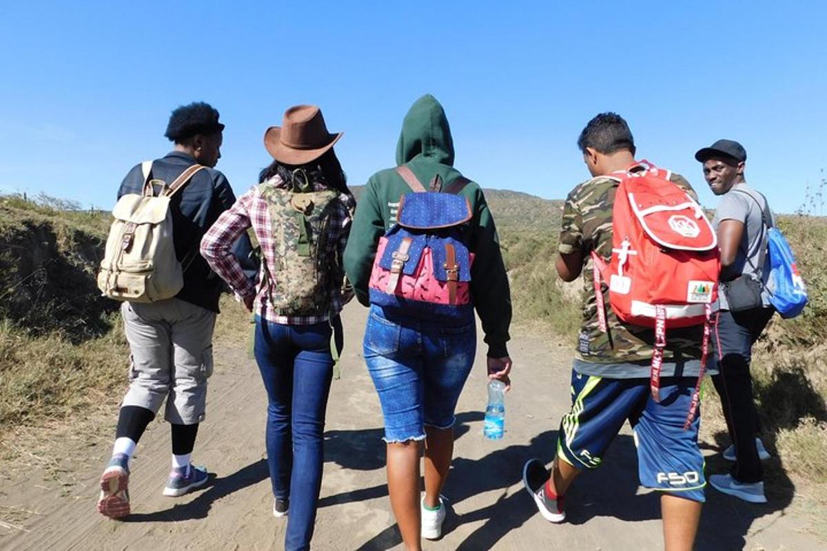 um grupo de pessoas caminhando por uma estrada de terra