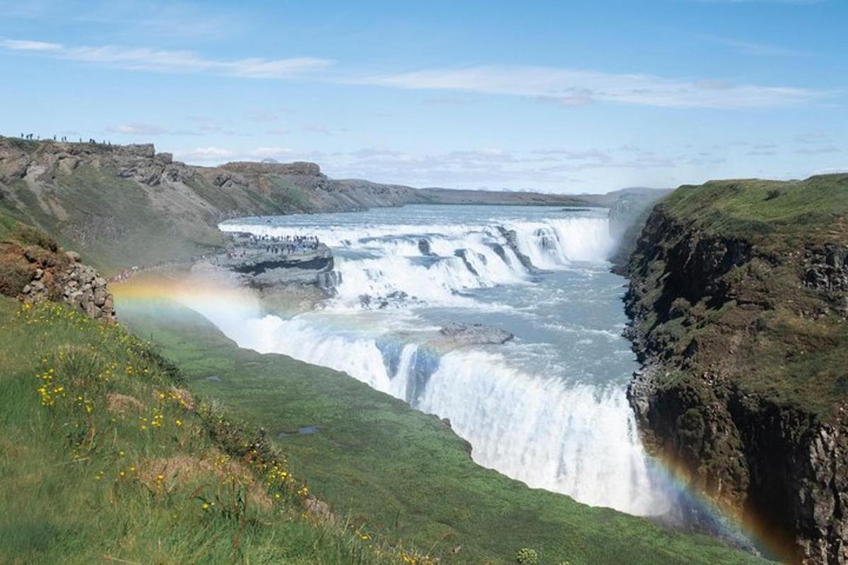 a waterfall with a rainbow in front of a river