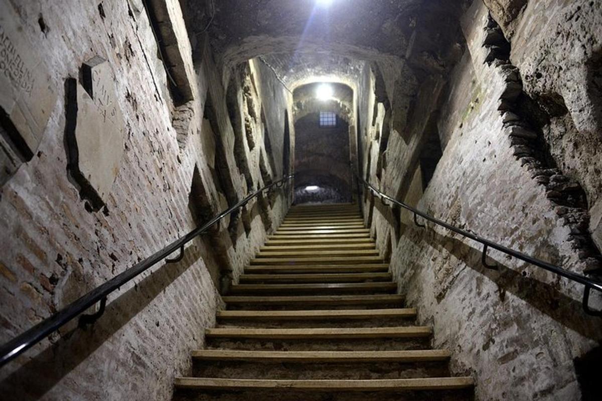 a staircase in a tunnel with a light at the top