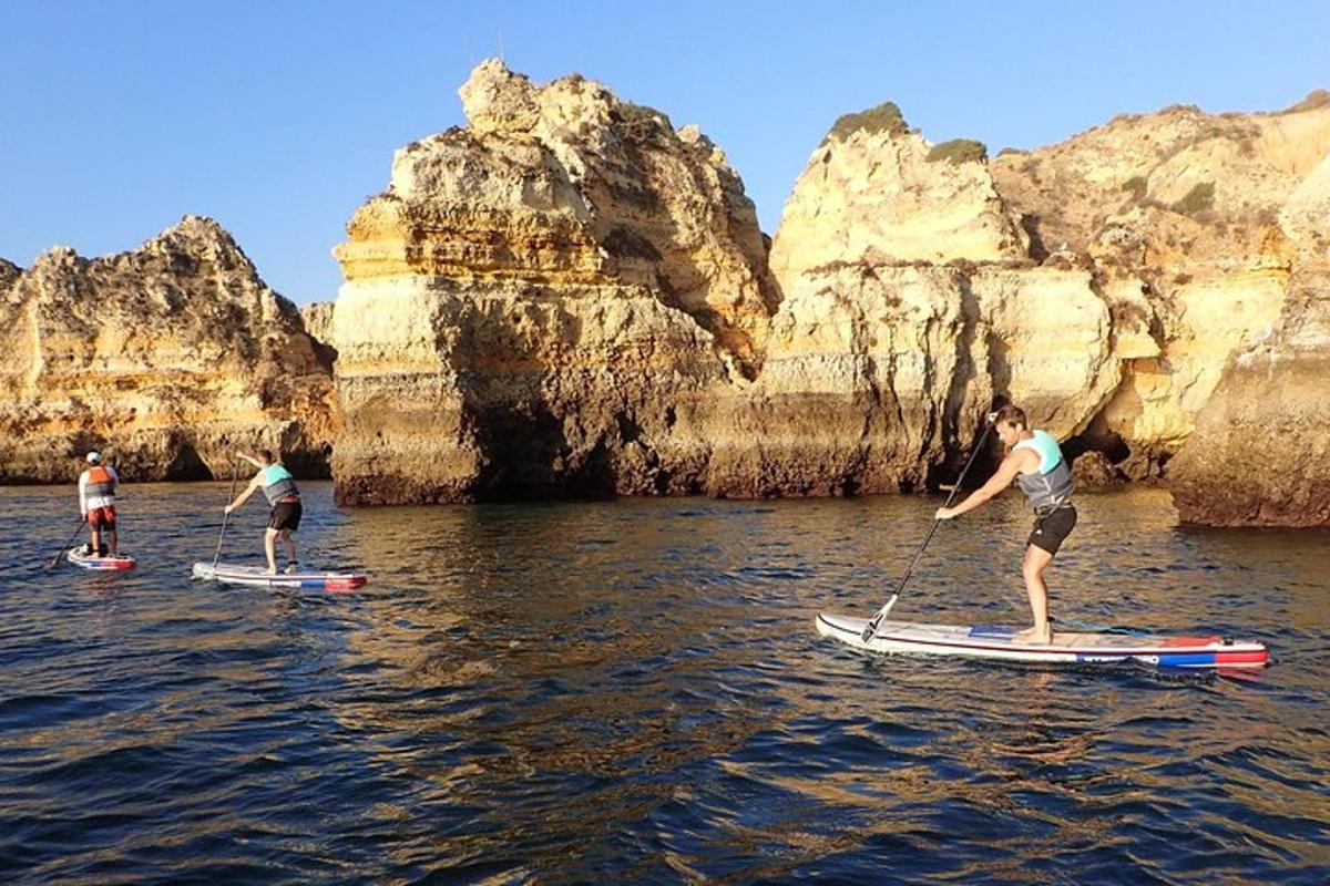 tre persone sono su tavole da paddle in acqua
