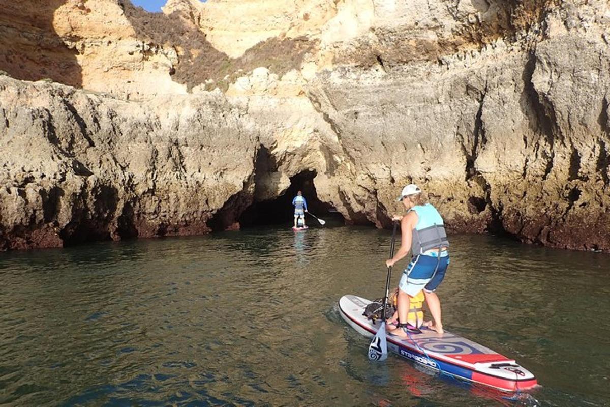 un uomo in piedi su una tavola da paddle in una grotta