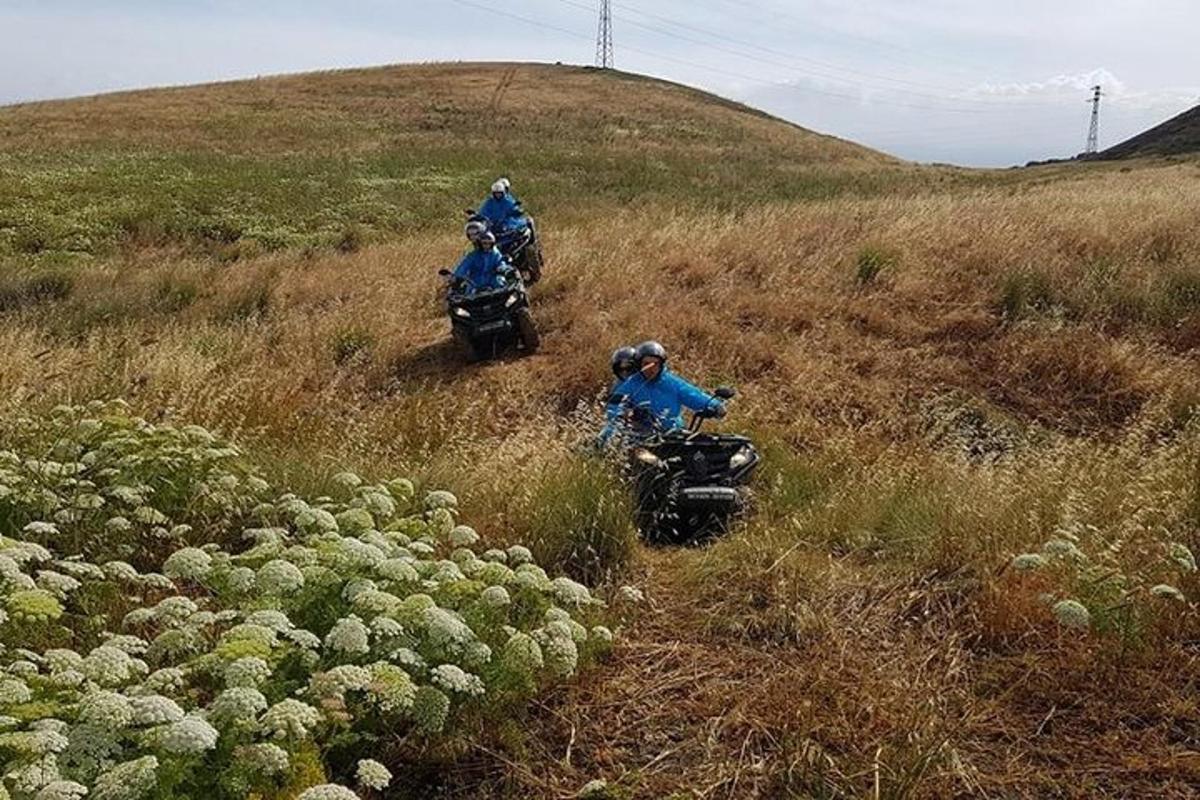skupina lidí jedoucích na motorkách z kopce