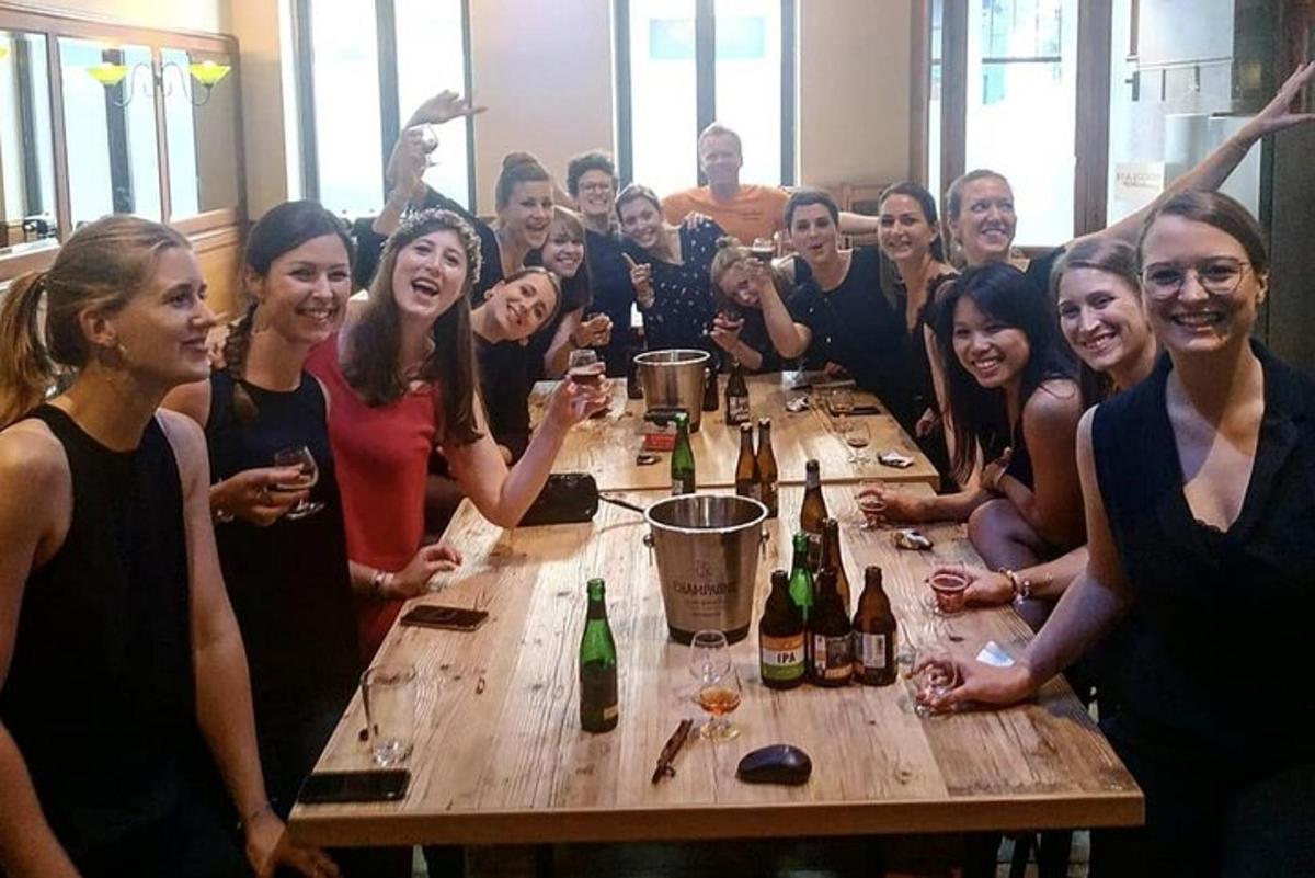 un grup de persones al voltant d'una taula amb ampolles de vi