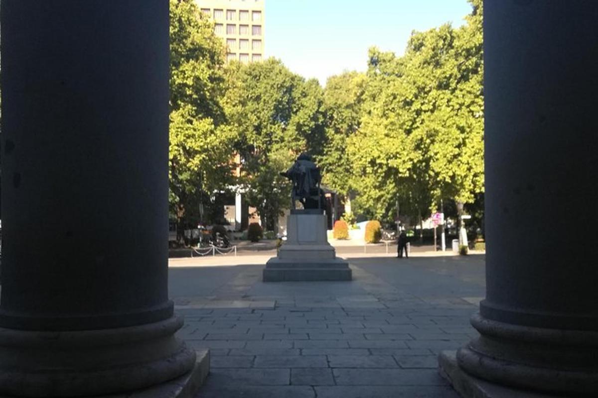 Egy férfi szobra egy parkban két oszlop között