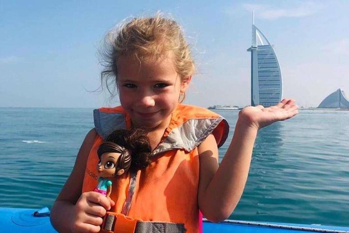 a young girl in a life vest on a boat in the water
