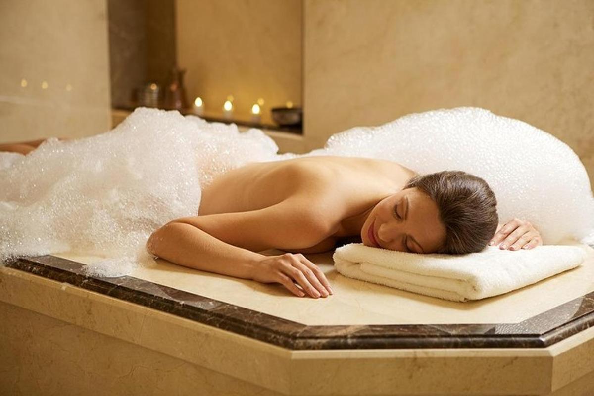 a naked woman laying on a towel in a bathtub
