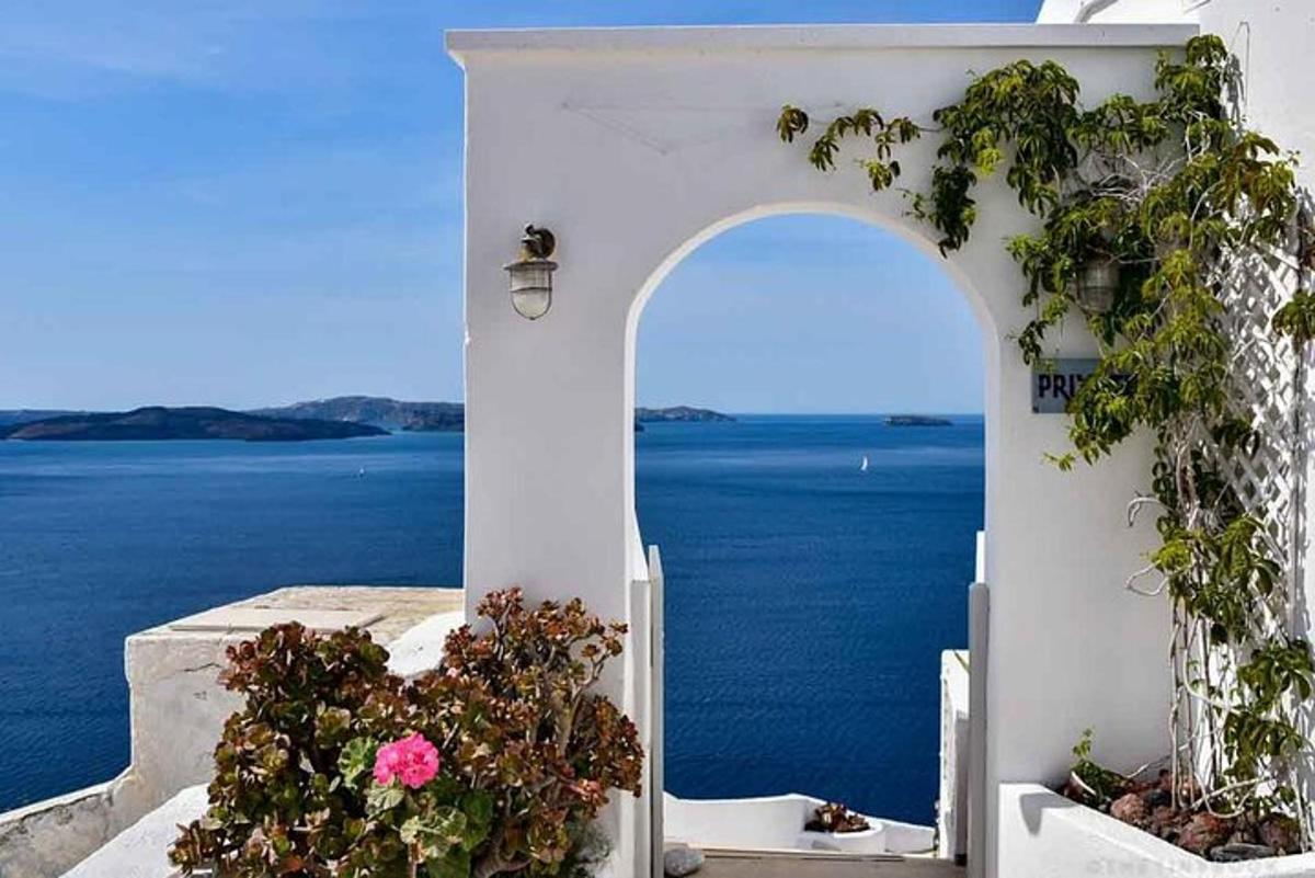 μια αψίδα με λουλούδια και θέα στον ωκεανό