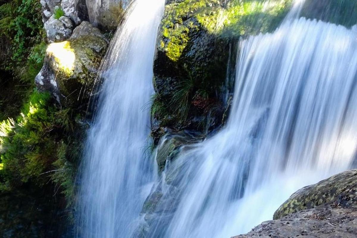 ein Wasserfall an der Seite eines Berges mit Felsen