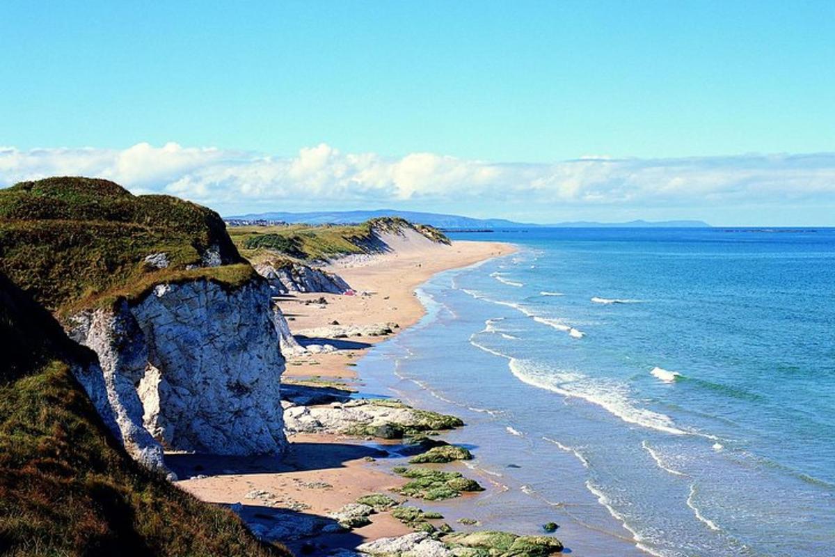 a beach with a large rock and the ocean