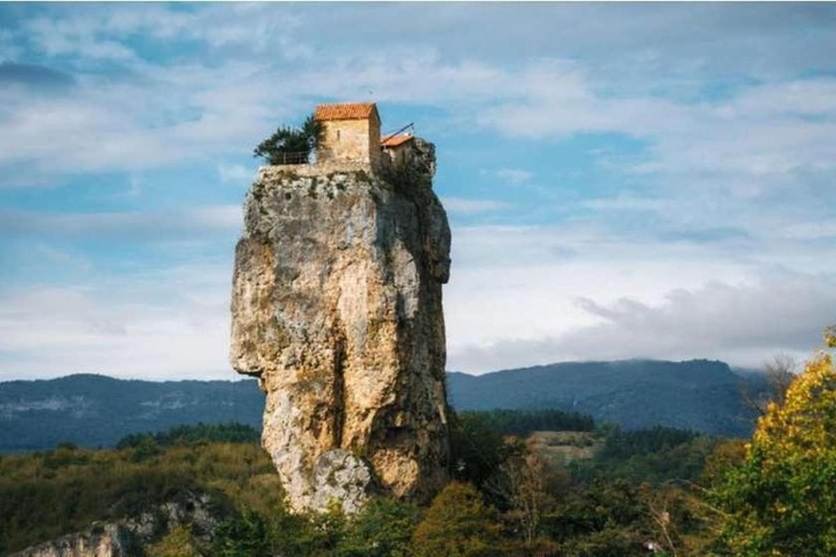 una formación rocosa con una casa encima