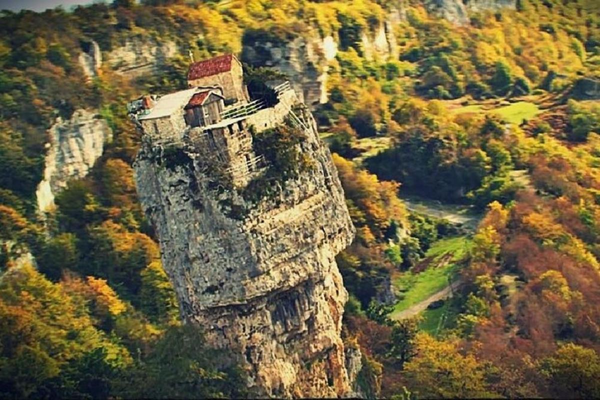 un castillo en la cima de una montaña con árboles