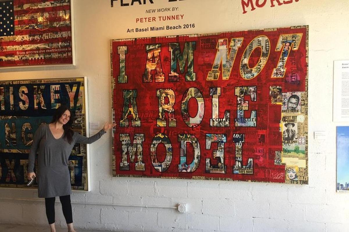 a woman standing in front of a wall with a large poster
