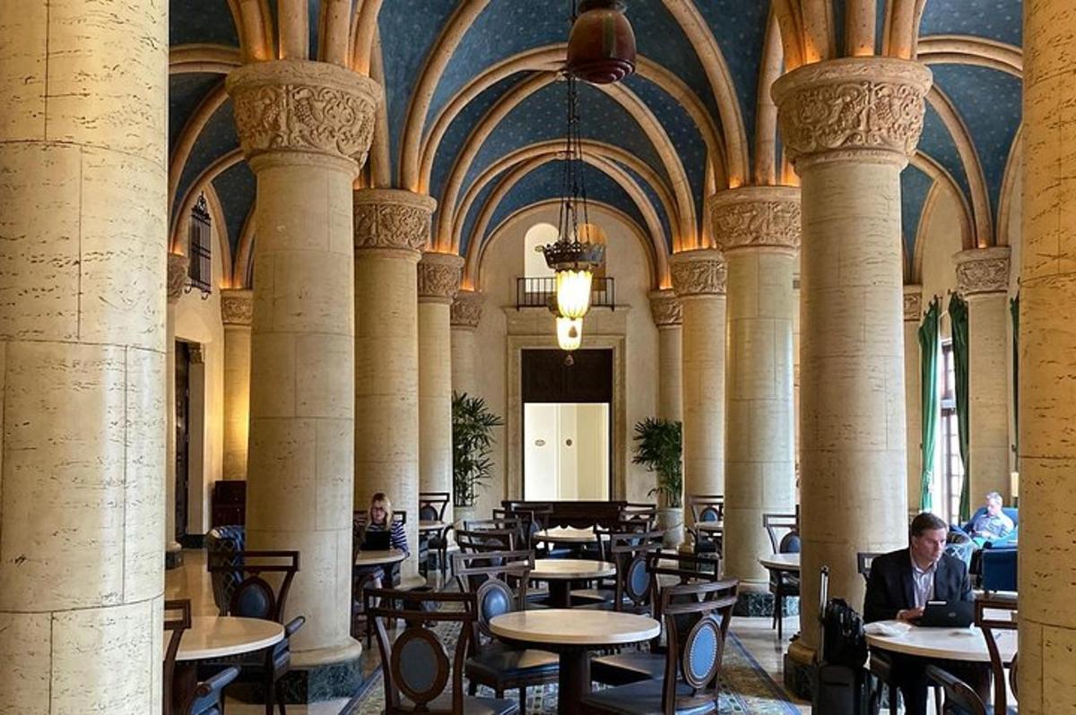 a room with tables and chairs in a building with columns