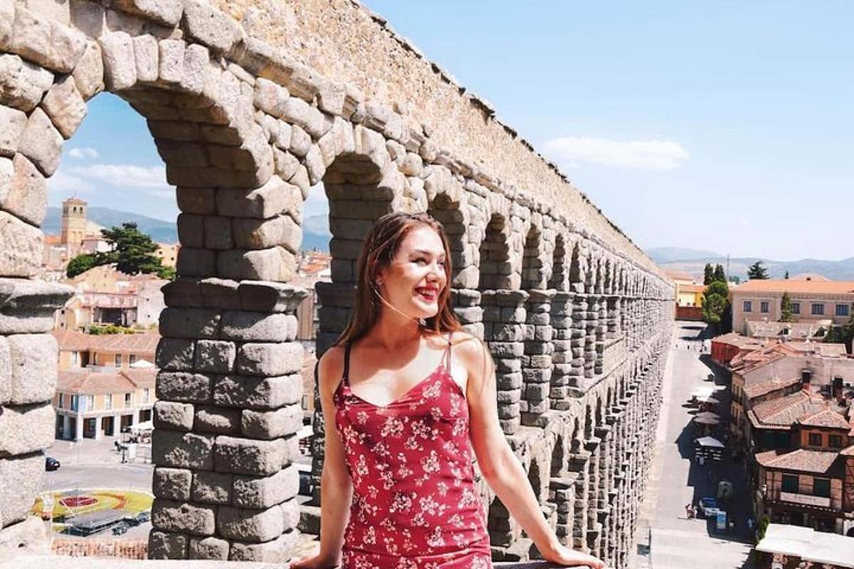 Una mujer con un vestido rojo parada en una pared
