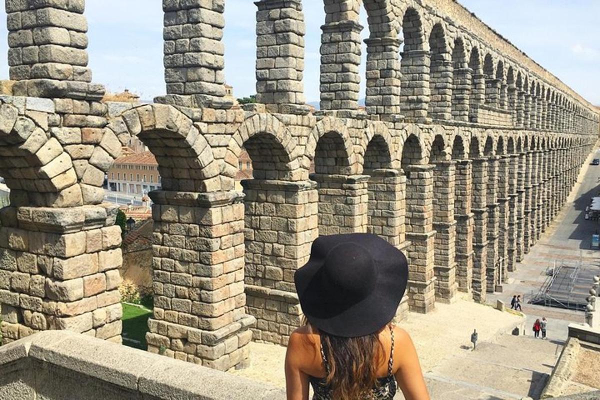 Una mujer con un sombrero negro mirando un anfiteatro.
