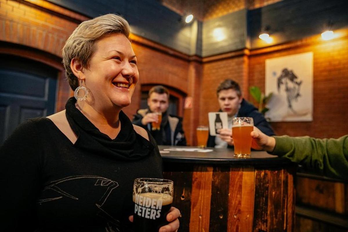 una dona dreta en un bar amb un got de cervesa a la mà