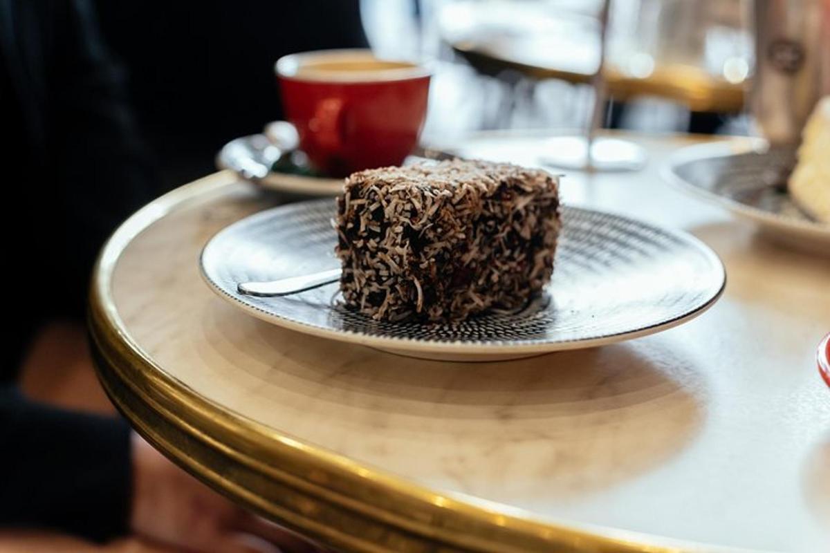 a piece of chocolate cake on a plate with a cup of coffee